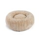 Ein plüschiges, rundes Haustierbett mit einem gerippten Design in einem sanften Beigeton, mit einem kleinen Etikett an der Seite.