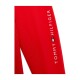 Rote Sportbekleidung mit dem weißen 'TOMMY HILFIGER'-Logo, mit einem kleinen Flaggenemblem und einem gepunkteten Texturdetail.