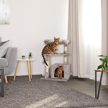Zwei Bengal-Katzen spielen auf einem grauen Katzenbaum in einem modernen Wohnzimmer, mit einem gemütlichen Sofa und Topfpflanzen in der Nähe.