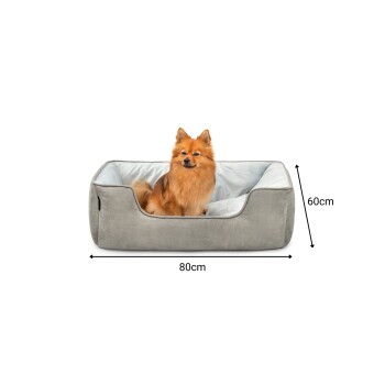 Ein flauschiger Pomeranian-Hund sitzt bequem in einem grauen Hundebett, das 80 cm mal 60 cm misst, mit einem weichen hellblauen Innenraum.