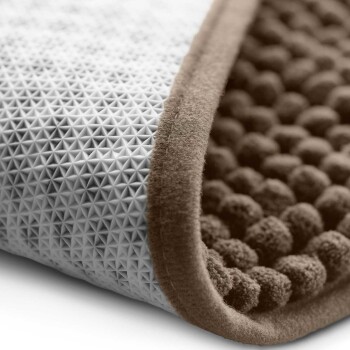Nahaufnahme einer Haustiermatte mit einer strukturierten grauen Oberfläche mit kleinen Pyramiden und einem weichen braunen Rand, die ihr doppelseitiges Design zeigt.