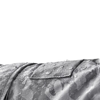 Nahaufnahme eines wasserdichten Haustiermantels mit Wassertropfen auf einem strukturierten grauen Stoff, der seine Haltbarkeit und Wetterbeständigkeit zeigt.