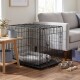 Schwarzer Metall-Hundekäfig mit grauem Bett im Wohnzimmer neben einem grauen Sofa, mit Edelstahlnäpfen und Seilspielzeug auf dem Parkettboden.