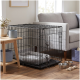 Schwarzer Metall-Hundekäfig mit grauem Bett im Wohnzimmer neben einem grauen Sofa, mit Edelstahlnäpfen und Seilspielzeug auf dem Parkettboden.