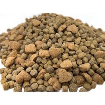 Eine Nahaufnahme eines Haufens Haustierfutterkibble, das verschiedene Formen zeigt, darunter kleine runde Stücke und herzförmige Bits in erdigen Tönen.