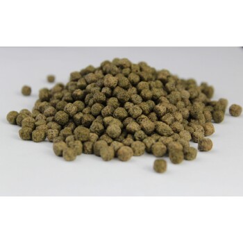 Nahaufnahme eines Haufens kleiner, runder, grünlich-brauner Haustierfutterpellets auf weißem Hintergrund.