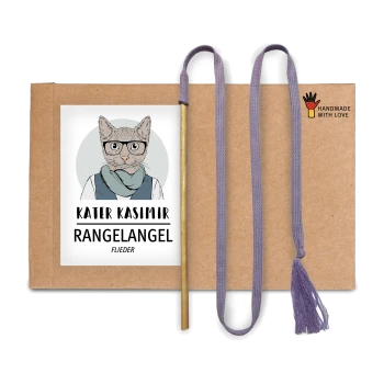 Eine Pappverpackung mit einer Katze in Brille und Schal, beschriftet mit "KATER KASIMIR," mit einem Zauberstab, lila Schnur und "HANDMADE WITH LOVE"-Logo.