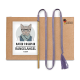 Eine Pappverpackung mit einer Katze in Brille und Schal, beschriftet mit "KATER KASIMIR," mit einem Zauberstab, lila Schnur und "HANDMADE WITH LOVE"-Logo.
