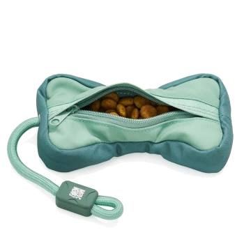Türkisfarbene, knochenförmige Leckertasche mit offenem Reißverschluss, der Trockenfutter zeigt, mit angebrachtem mintfarbenem Seilgriff und Schieber mit weißem Logo.