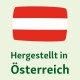 Eine rot-weiße Flagge, die Österreich repräsentiert, über dem Text "Hergestellt in Österreich" auf einem hellgrünen Hintergrund.