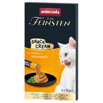 Eine weiße Katze leckt sich die Lippen neben einem Teller mit cremigem Snack, mit der Verpackung "animonda vom Feinsten Snack Cream" mit Huhn und Katzenkraut.