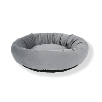 Lit pour animal de compagnie rond et moelleux en tissu gris doux avec un fond noir, conçu pour le confort et la détente.