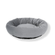 Round, plush pet bed in soft gray fabric with a black bottom, designed for comfort and relaxation.