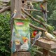 Ein Nymphensittich, der Samen aus einer Holzschüssel frisst, mit einer grünen Tüte Panto-Vogelfutter im Hintergrund, die mit "Großsittich und Papagei" beschriftet ist.