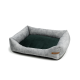 Graues Hundebett mit einem weichen grünen Kissen in der Mitte, mit erhöhten Seiten für Komfort und einem kleinen braunen Etikett.