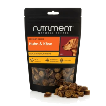 Schwarze Nutriment Natural Treats-Tüte mit Aufschrift 'Huhn & Käse' 200 g und Hundefoto; runde Gourmet-Scheiben vorne verstreut.