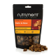 Schwarze Nutriment Natural Treats-Tüte mit Aufschrift 'Huhn & Käse' 200 g und Hundefoto; runde Gourmet-Scheiben vorne verstreut.