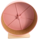 Ein pinkfarbener Trainingsrad für kleine Haustiere, mit einem Kork-Innenraum und einem Holzsockel, entworfen für sichere und unterhaltsame Aktivitäten.