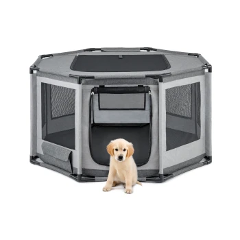 Ein hellgoldener Retriever-Welpe sitzt vor einem grauen achteckigen Haustierspielzaun mit Netzseiten und einem Reißverschluss-Eingang.