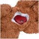 Gros plan d'un jouet ours en peluche marron avec une boîte à son en forme de cœur rouge cachée à l'intérieur, avec un bouton d'alimentation.