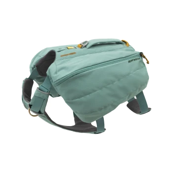 Ein türkisfarbener Hunderrucksack mit verstellbaren Riemen, mit einer vorderen Reißverschlusstasche und einem Griff oben, beschriftet mit "RUFFWEAR."