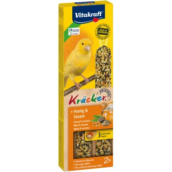 Vitakraft Kräcker Vogelsnackverpackung mit einem gelben Kanarienvogel, zwei "Honig & Sesam"-Saatenstangen und Text über Vitamine und ohne Zuckerzusatz.