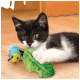 Chaton noir et blanc allongé sur le sol, serrant un jouet feuille vert en peluche et un jouet chenille bleu.