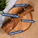 Ein großer Hundeknochen auf einem Holzbrett, beschriftet mit Text auf Deutsch: "calciumreich," "natürliche Zahnpflege," "gut verträglich," und "langer Kauspaß."