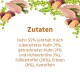 Ein flauschiger brauner Hund sitzt glücklich mit herausgestreckter Zunge neben einem Haufen Hundefutterkibble, das mit "ADULT" beschriftet ist und die Maße 14 mm x 5 mm hat.