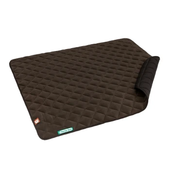 Eine dunkelbraune, gesteppten Haustiermatte mit einer gefalteten Ecke, mit einem kleinen orangefarbenen Etikett und einem grünen "Doctor Bark"-Label.