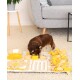 Kleiner brauner Hund schnüffelt an einer gelb-beigen interaktiven Schnüffelmatte auf einem Teppichboden im Wohnzimmer.