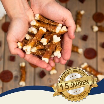 Hände halten einen Stapel Hundeleckerlis in Knochenform, mit einem Abzeichen, das "Beste Qualität" und "15 Jahre" auf Deutsch angibt.