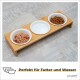 Bambus-Futterstation für Haustiere mit drei weißen Schalen: Nassfutter, Wasser und Trockenfutter. Text sagt "Perfekt für Futter und Wasser."