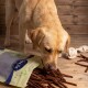 Hände halten einen Haufen brauner Haustier-Leckerlis, mit einem Abzeichen, das "Beste Qualität" und "15 Jahre" auf Deutsch angibt, was 15 Jahre Qualität bedeutet.
