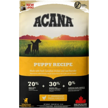 ACANA Puppy Recipe Hundefutterbeutel mit zwei Hunden auf einem Feld, der frisches kanadisches Huhn, rohe Flunder und 70 % hochwertige tierische Zutaten hervorhebt.