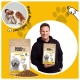 DOGS'n TIGER Hundefuttersack 'Federtanz Saftiges Huhn & Ente mit Gemüse' in der Hand eines Mannes, Krokettenhaufen, gelber Hintergrund.