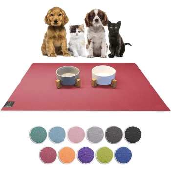 Eine rote Haustiermatte mit zwei Futter-/Wasserschüsseln auf Holzständern, umgeben von verschiedenen farbigen Mustern, mit Hunden und Katzen im Hintergrund.