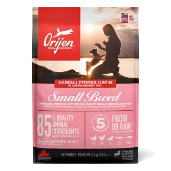 Tüte Orijen Small Breed Hundefutter mit einem pinken und weißen Design, das "85% Qualitäts-Tierzutaten" und "Frisch oder Roh" angibt.