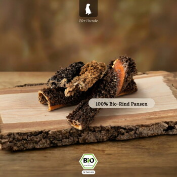 Getrocknete Rinderpansen-Kausnacks für Hunde auf einem Holzbrett mit Bio‑Siegel; sichtbarer Text „100% Bio‑Rind Pansen“ und „Für Hunde“