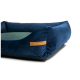 Ein plüschiges, marineblaues Haustierbett mit einem grünen Kissen in der Mitte, mit einem braunen Etikett, das auf der Seite "REXPRODUCT.COM" liest.