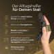 Hand hält eine schwarze Pferdepflegebürste mit Riemen neben der deutschen Überschrift „Der Alltagshelfer für Deinen Stall“