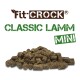 Fit-Crock Classic Lamm Mini Haustierfutterpellets, die einen Haufen kleiner, bräunlich-grüner Kibble-Stücke zeigen.