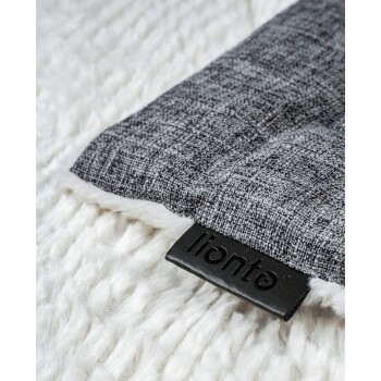 Nahaufnahme einer grauen Haustierdecke mit einer weichen weißen Unterseite, die ein schwarzes "lionto"-Etikett trägt.