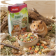 Ein neugieriger Hamster schaut aus einem blauen Rad neben einer bunten Tüte Panto Hamsterfutter, das seine vielfältige Mischung und Vitamine zeigt.
