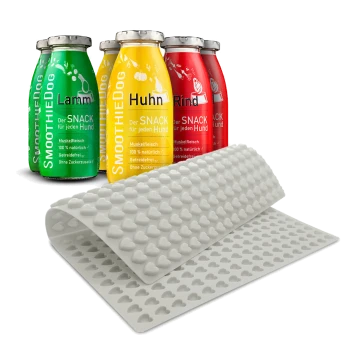 Vier bunte Smoothie-Flaschen für Hunde mit den Aufschriften "Lamm", "Huhn" und "Rind", neben einer rosa Silikonmatte mit Herzformen.