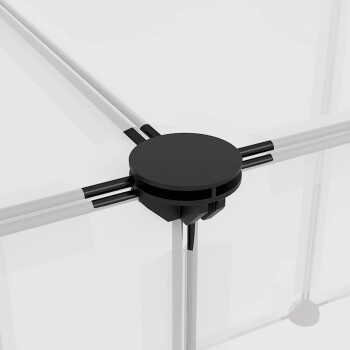 Ein niedlicher grauer Kaninchen sitzt auf einem weißen Regal in einem transparenten Haustiergehege, mit einer sichtbaren Metallrampen.