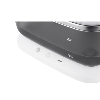 Nahaufnahme eines Haustier-Wasserbrunnens mit einem eleganten schwarzen Oberteil und einem weißen Sockel, mit MAX- und MIN-Wasserstandsanzeigern.