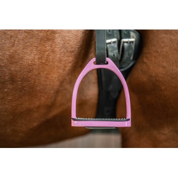 Nahaufnahme eines rosa Pferdestirrup mit der Aufschrift 'EQUINATE', der an einem Sattel gegen die Flanke eines braunen Pferdes befestigt ist.