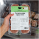 Hand hält Barfer's "Komplett‑Mix Lamm für Katzen" Rohfutter-Packung (400 g) in einem Gefrierschrank.