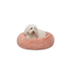 Ein flauschiger weißer Hund ruht sich in einem runden, weichen, rosa Haustierbett aus, das ein gemütliches und komfortables Design zeigt.
